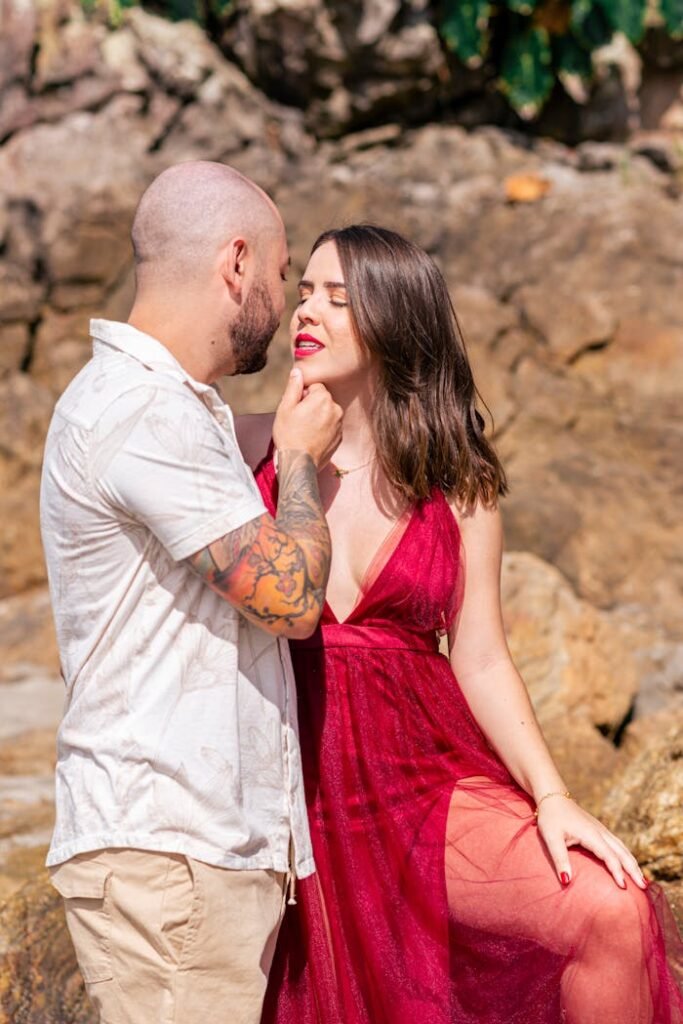 A couple expresses affection in a warm outdoor setting, captured embracing romance in a lovely pose.